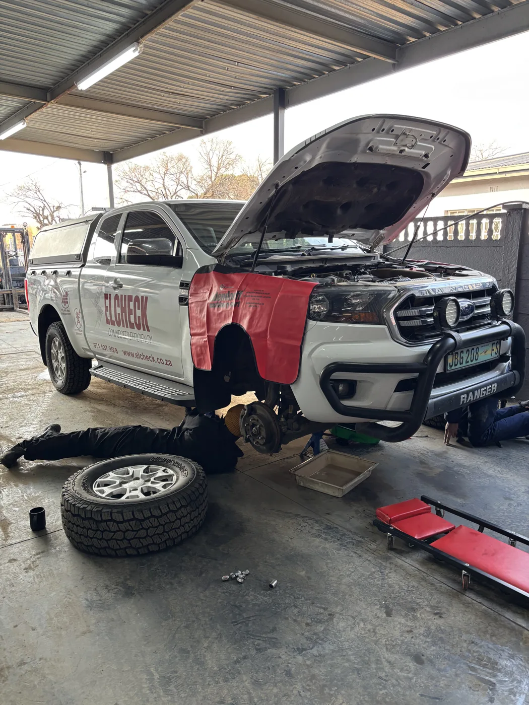 A vehicle with its bonnet open in the workshop