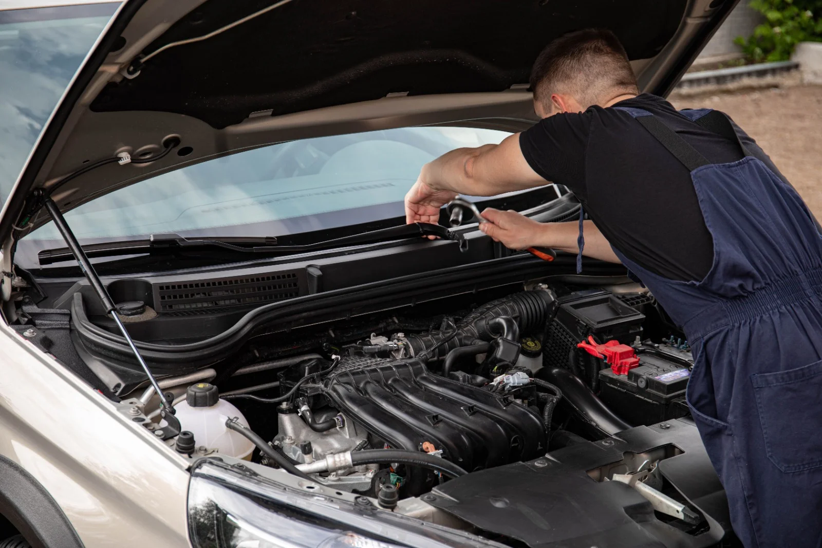 Mechanic servicing a vehicle with its bonnet open